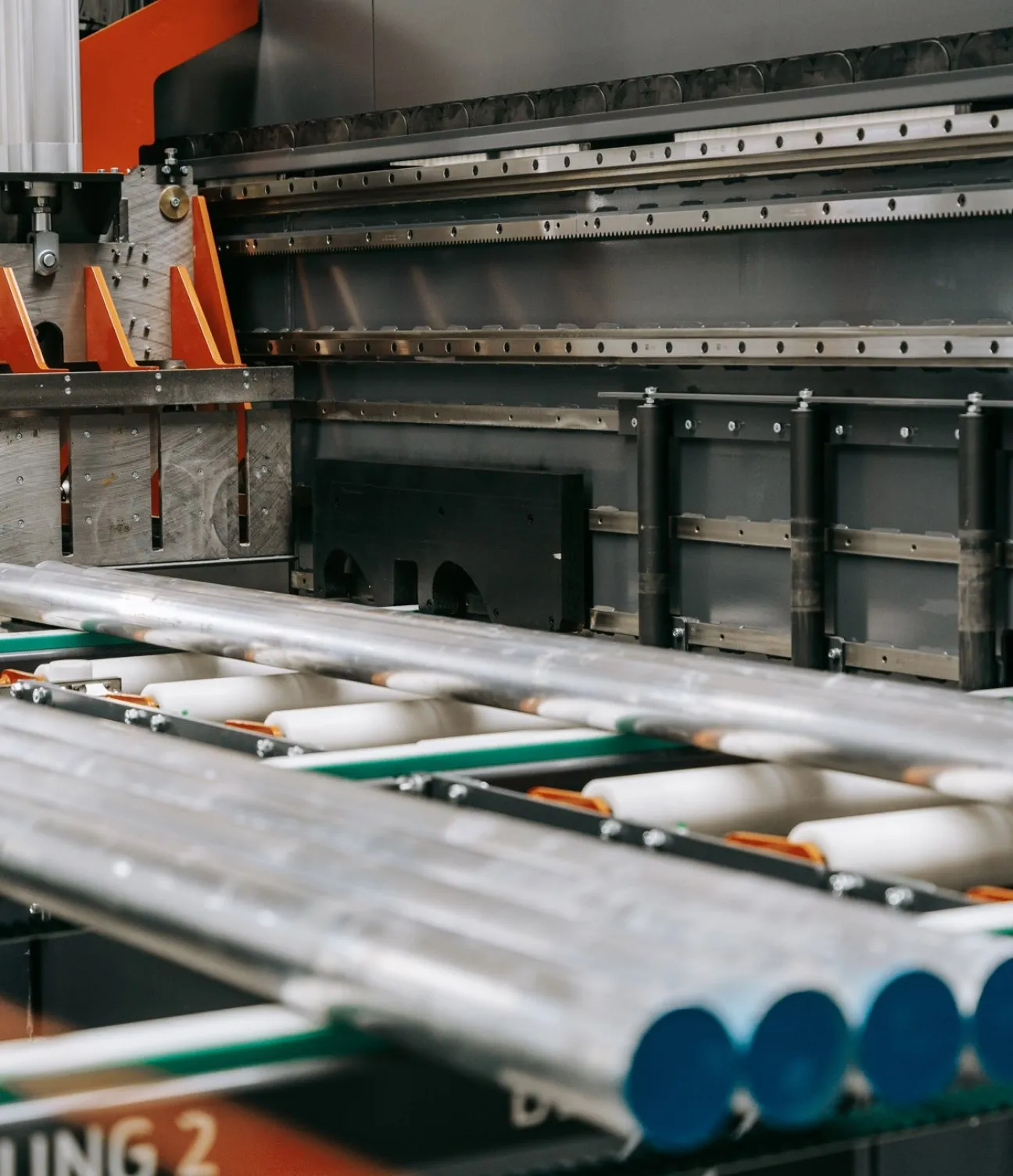 Detailansicht der Briganto CrossCut Profil- und Ablängsäge: Aluminiumrohre auf der automatischen Beschickungseinheit während des Bearbeitungsprozesses.