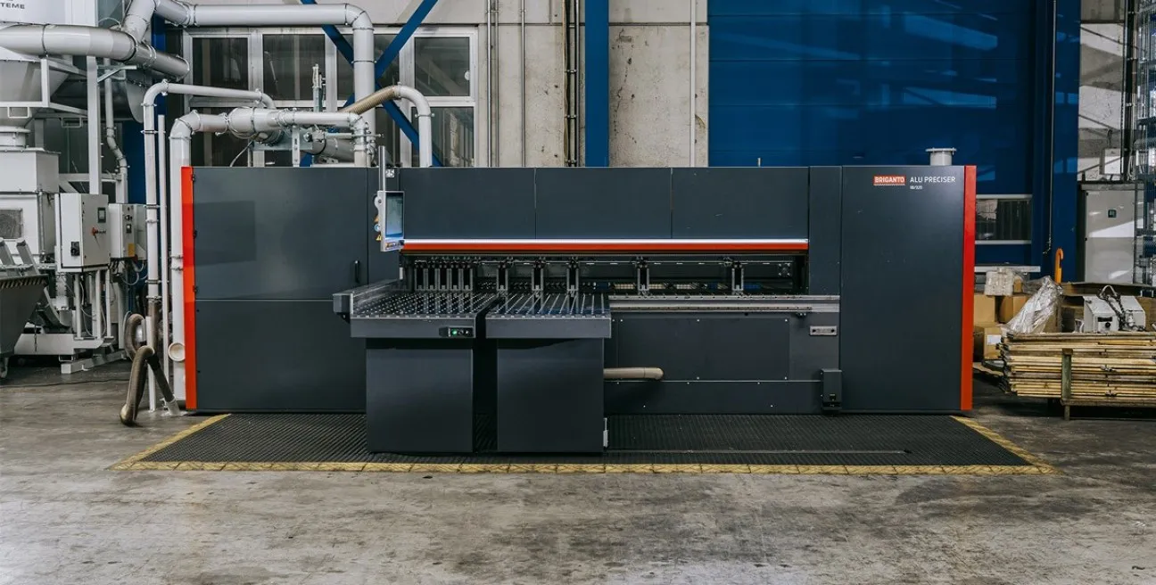 Vorderansicht der Briganto AluPreciser Plattensäge in Grau und Blutorange mit integriertem Bedien-Terminal in einer Industrieumgebung